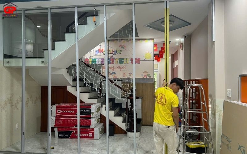 Đội ngũ thợ từ đơn vị thi công vách ngăn nhựa uy tín đang lắp đặt khung xương sắt